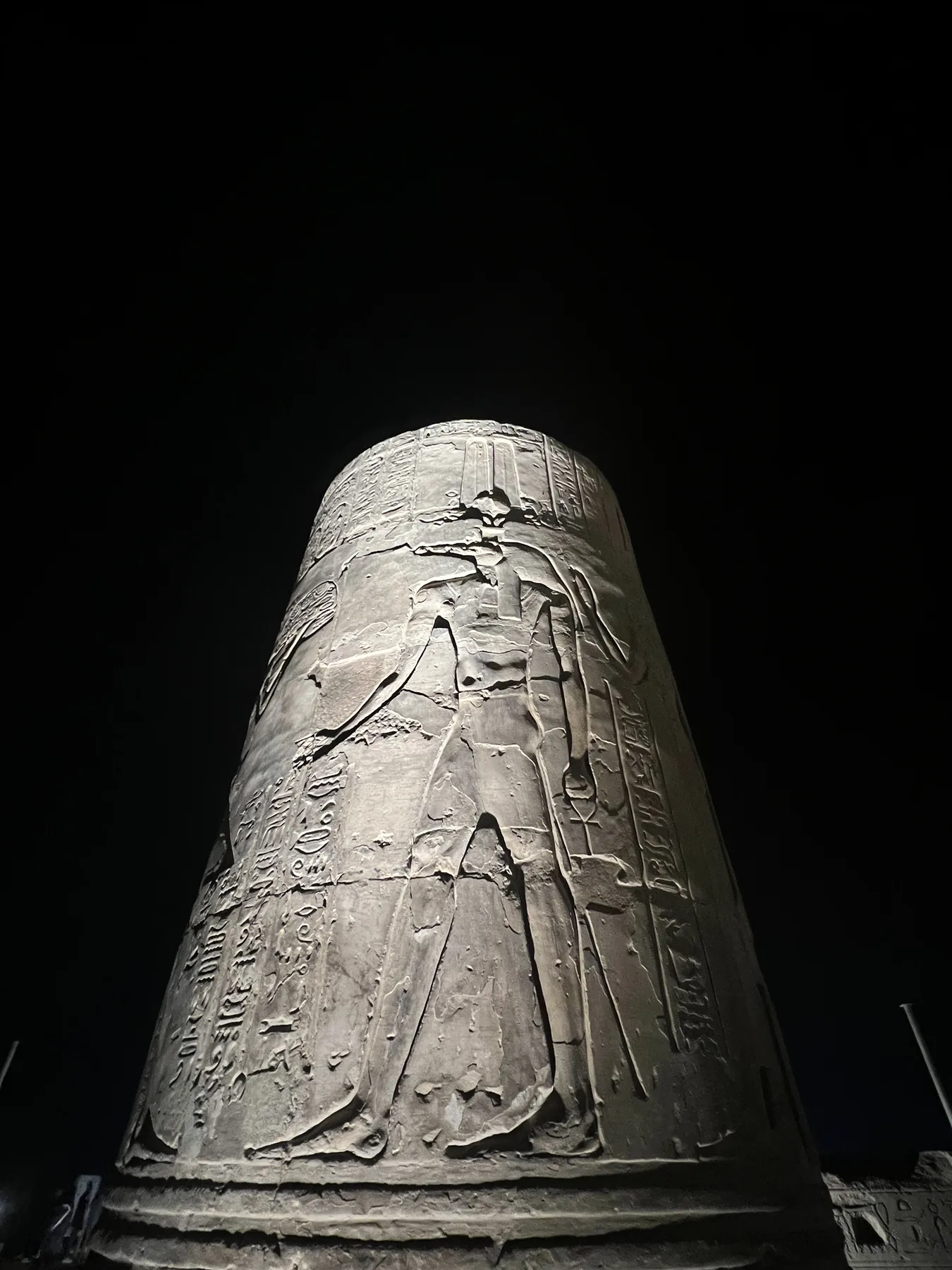 Carved temple column illuminated during an evening visit to Kom Ombo