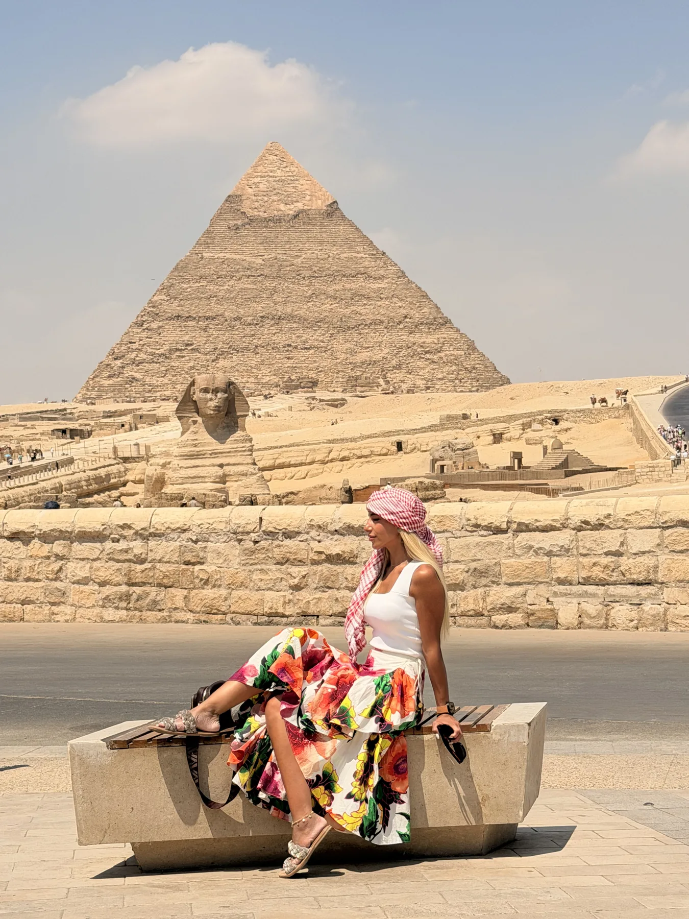 Visitor beside the Great Sphinx with a Giza pyramid in the background